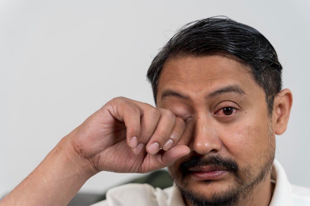 Close-up image of man rubbing his eye, highlighting eye care and LASIK eye surgery services at Punjab Lasik.